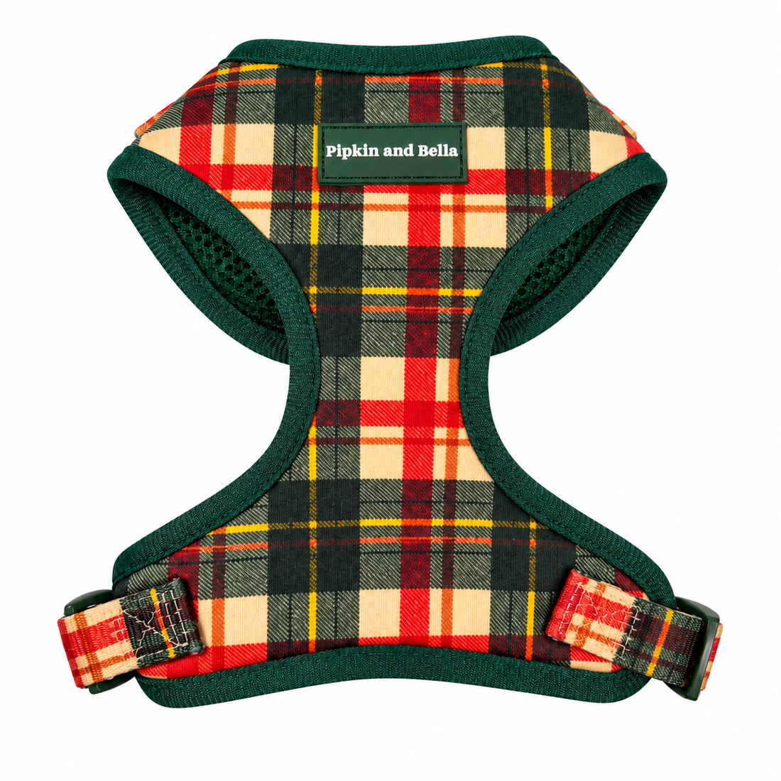 A dog harness with a red, yellow, and beige plaid pattern and dark green trim, featuring a green brand label that reads 'Pipkin and Bella'.